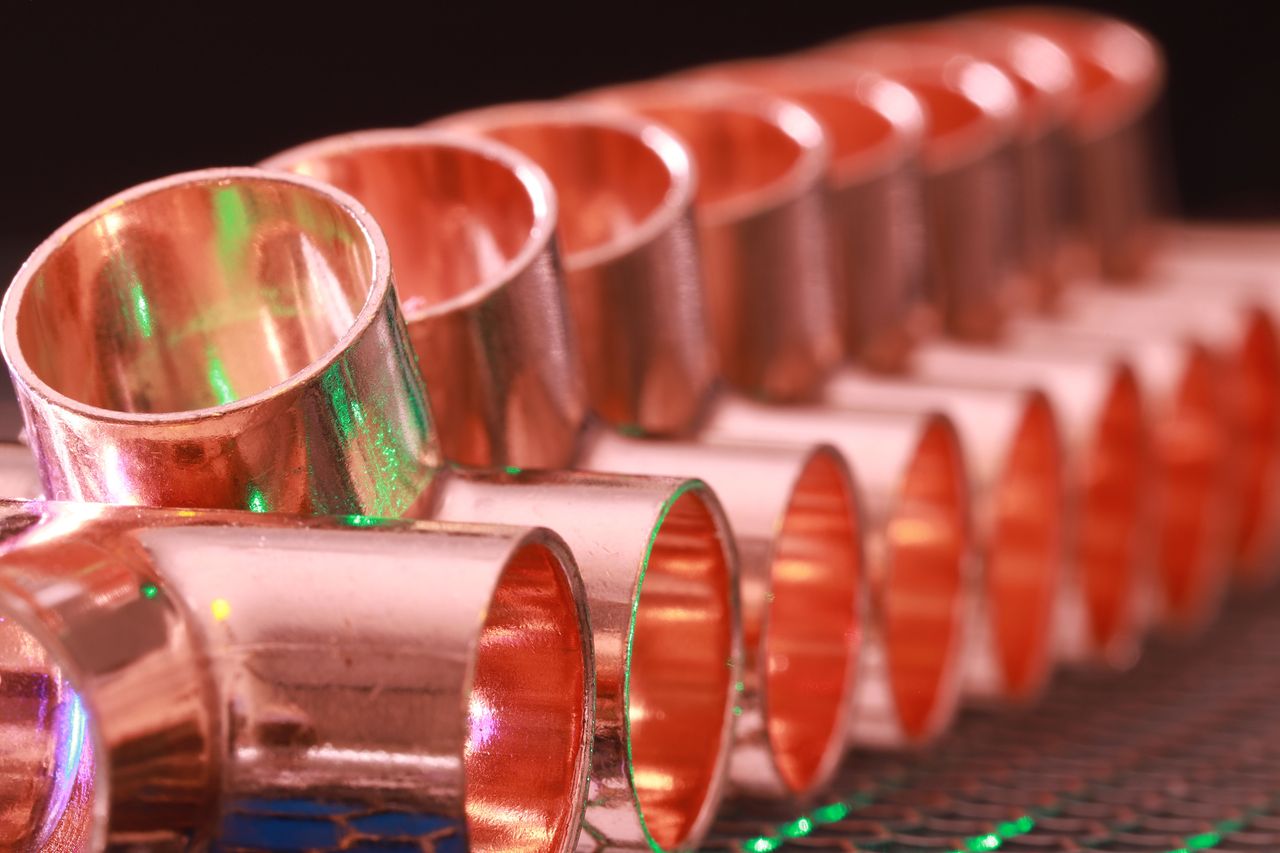 Copper elbow and connector fittings arranged on a work surface